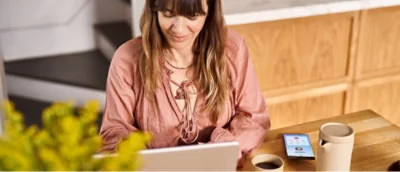 En kvinna sitter vid ett skrivbord och använder en bärbar dator.