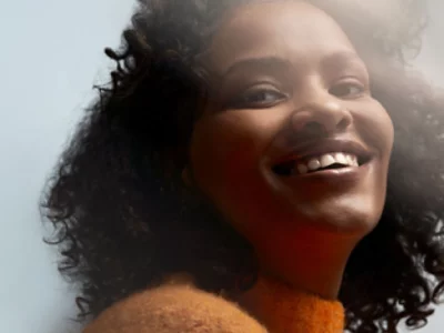 En kvinna i kort hår ler