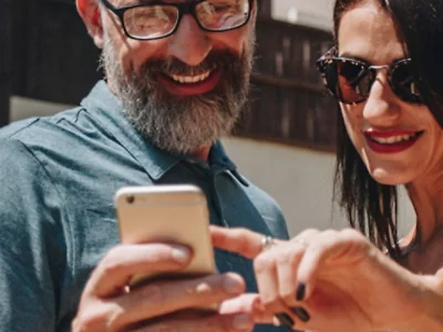 En kvinna och en man som tittar på en mobiltelefon.