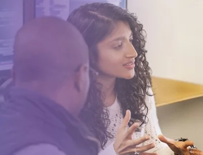 Two individuals conversing, one gesturing expressively with hands