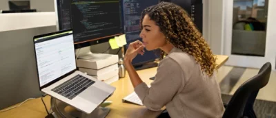 A woman sitting at the table and looking at a computer