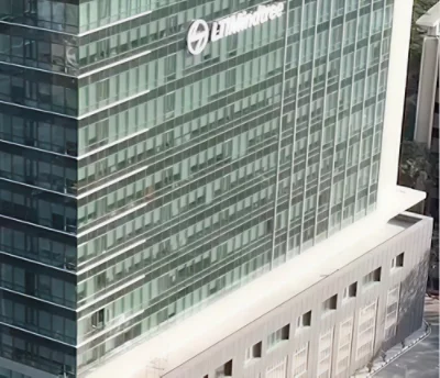 Interiör från en fabrik med avancerade maskiner, synliga rör och en arbetare i skyddskläder. 