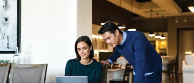 Två personer i det moderna rummet som tittar på bärbar dator tillsammans