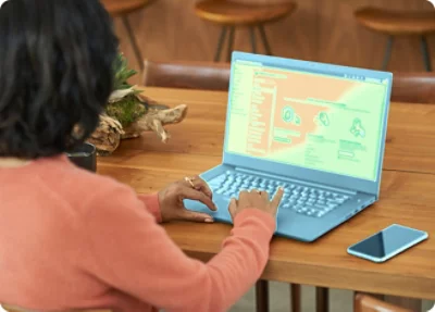 Woman in orange sweater using laptop displaying a website about data security on its screen at a wooden table