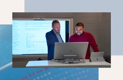 A group of men standing in front of a computer.