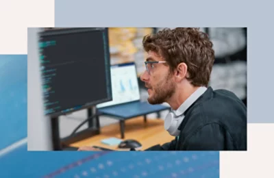 A person wearing glasses and headphones looking at a computer screen.