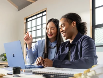 A woman and a men is looking to a laptop