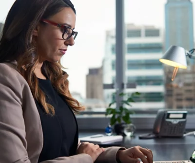 En person i glasögon som tittar på en dator