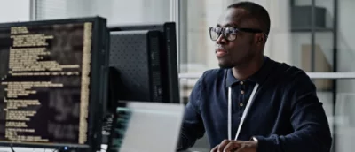 A man sitting at a desk with a computer screen visible.