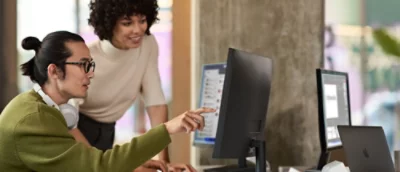 A person pointing at a computer screen.