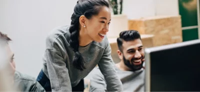Piccolo gruppo che collabora attorno a uno schermo di computer in uno spazio di lavoro condiviso.
