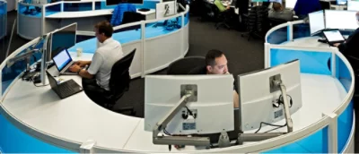 En man sitter vid ett skrivbord och använder en bärbar dator.