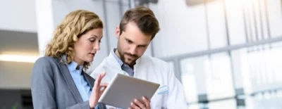 Uma pessoa a segurar um tablet e a falar com outra pessoa