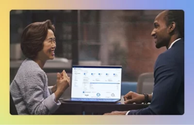 En man och kvinnor tittar på skärmen på en bärbar dator och diskuterar