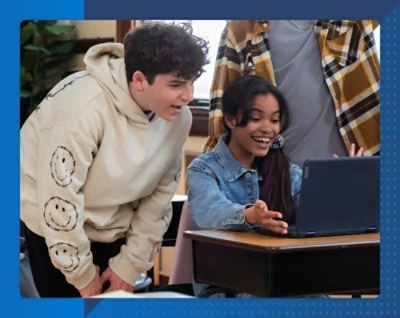 Ein junger Mann und ein Mädchen schauen auf einen Laptop.