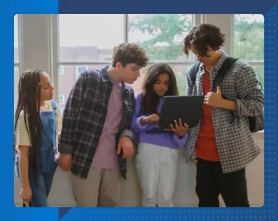 Eine Gruppe junger Menschen ist um einen Laptop versammelt.