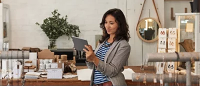A women smiling while looking at a tablet.