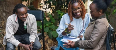 Tre personer i en trädgård