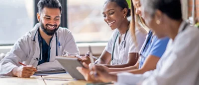 Tre läkare som ler och diskuterar