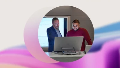 Två personer arbetar vid en bärbar dator