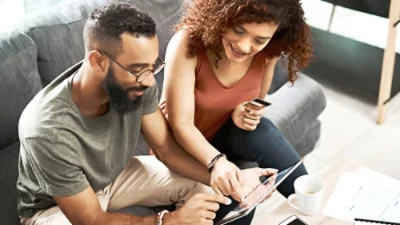 En man och en kvinna som tittar på en surfplatta.