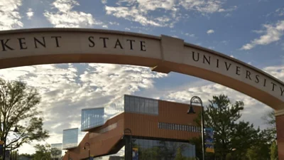En valvgång av sten med överskriften Kent State University leder till ett campus