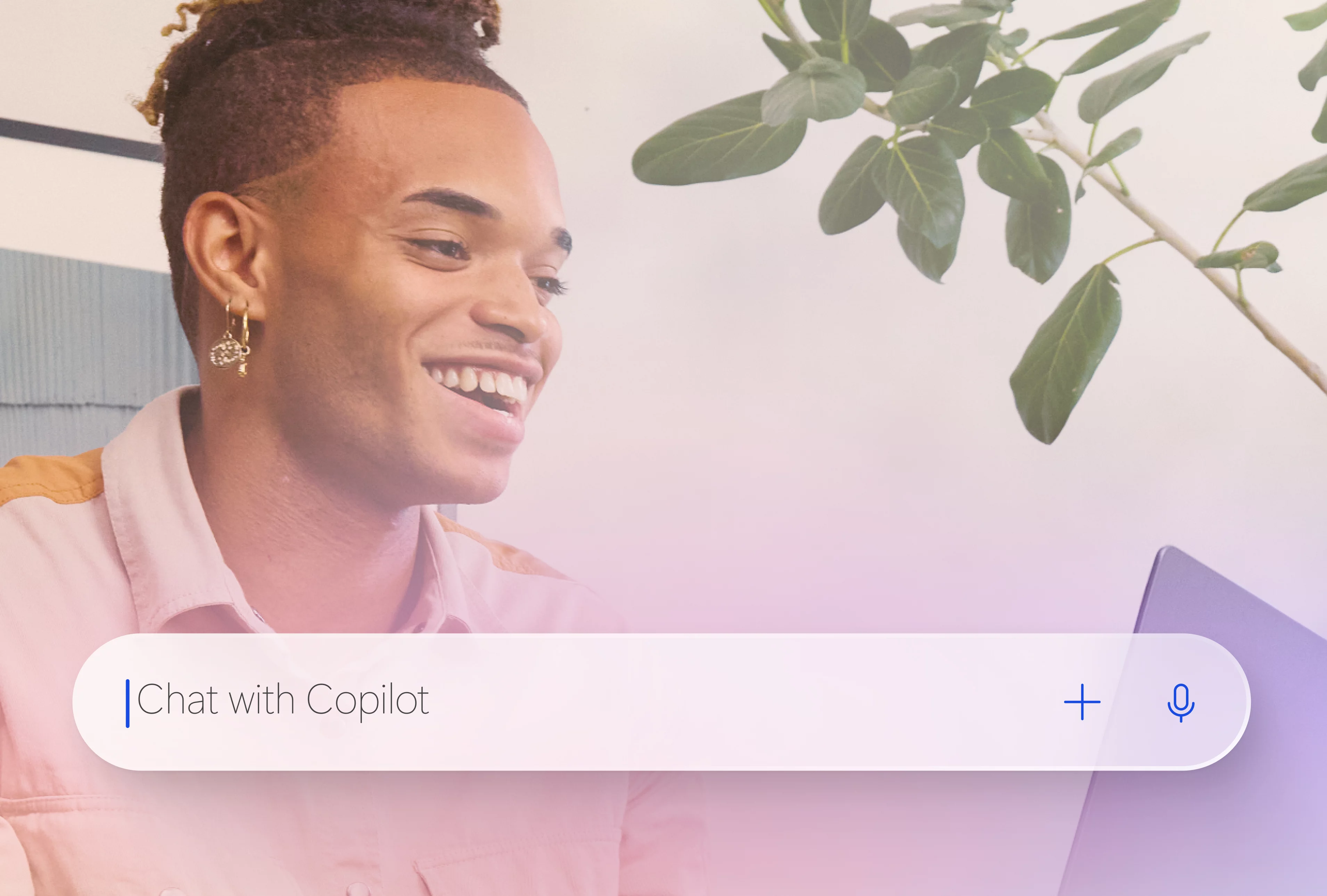 A smiling man looking at an open laptop with a Copilot search bar on top