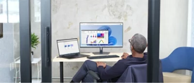 En man sitter vid ett skrivbord med en dator som visar ett diagram.