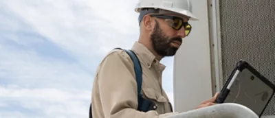 Mężczyzna w kasku używający laptopa