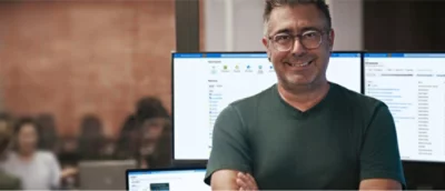 En man med glasögon ler.