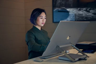 A woman staring at computer screen on a table