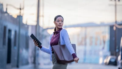 A woman walking with a tablet in hand