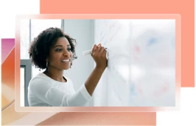 En kvinna med lockigt hår som skriver på en whiteboard.