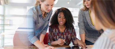 Group of colleagues collaborating on a project around a table in an office setting.