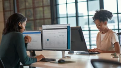 En man och en kvinna sitter vid ett bord och använder en dator.