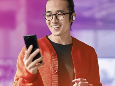 en person tittar på en mobiltelefon med ett leende