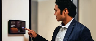 Un bărbat cu sacou albastru care atinge un dispozitiv