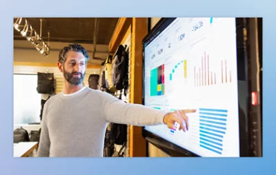 Person presenting data on a large screen with various charts and graphs.