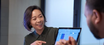A woman pointing at a laptop.