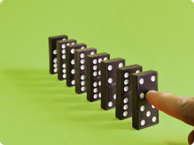 A finger pushing a domino.